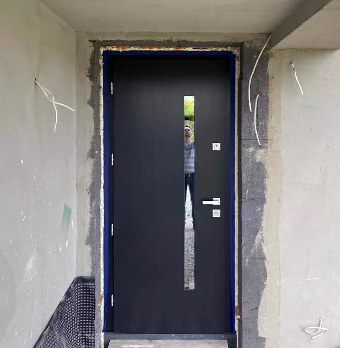 Widok elewacji domu z zamontowanymi drzwiami wzór 417,11 wymalowanymi w kolorze antracytowe.