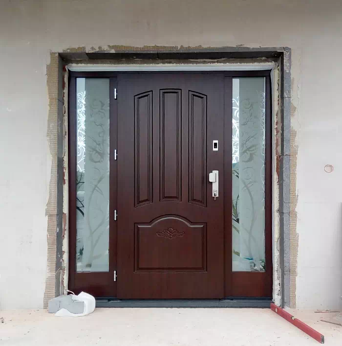 Widok elewacji domu z zamontowanymi drzwiami wzór 502,1+d1 wymalowanymi w kolorze orzech.