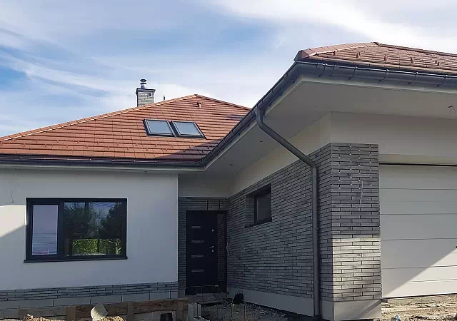 Widok elewacji domu z zamontowanymi drzwiami wzór 481,3 wymalowanymi w kolorze antracyt.