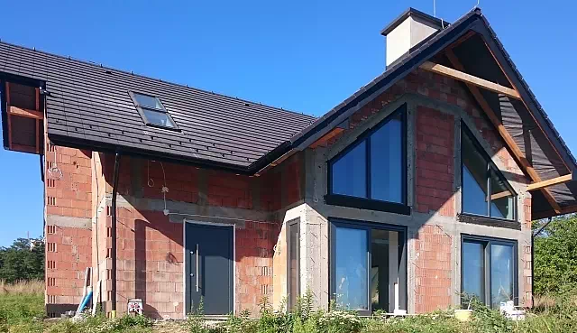 Widok elewacji domu z zamontowanymi drzwiami wzór 500C wymalowanymi w kolorze antracyt.