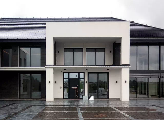 Widok elewacji domu z zamontowanymi drzwiami wzór 500C wymalowanymi w kolorze czarne.