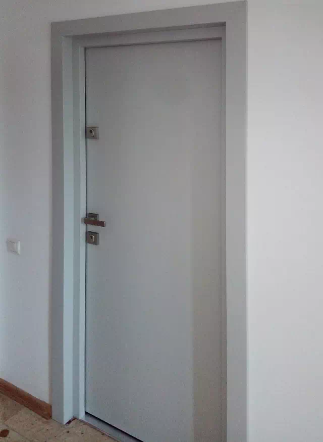 Widok elewacji domu z zamontowanymi drzwiami wzór 500C wymalowanymi w kolorze białe.