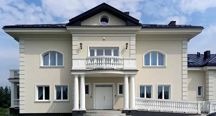 Widok elewacji domu z zamontowanymi drzwiami wzór 534,9 wymalowanymi w kolorze białe.