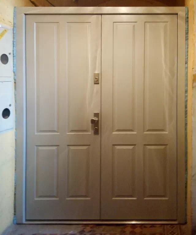 Widok elewacji domu z zamontowanymi drzwiami wzór 534,9 wymalowanymi w kolorze białe.