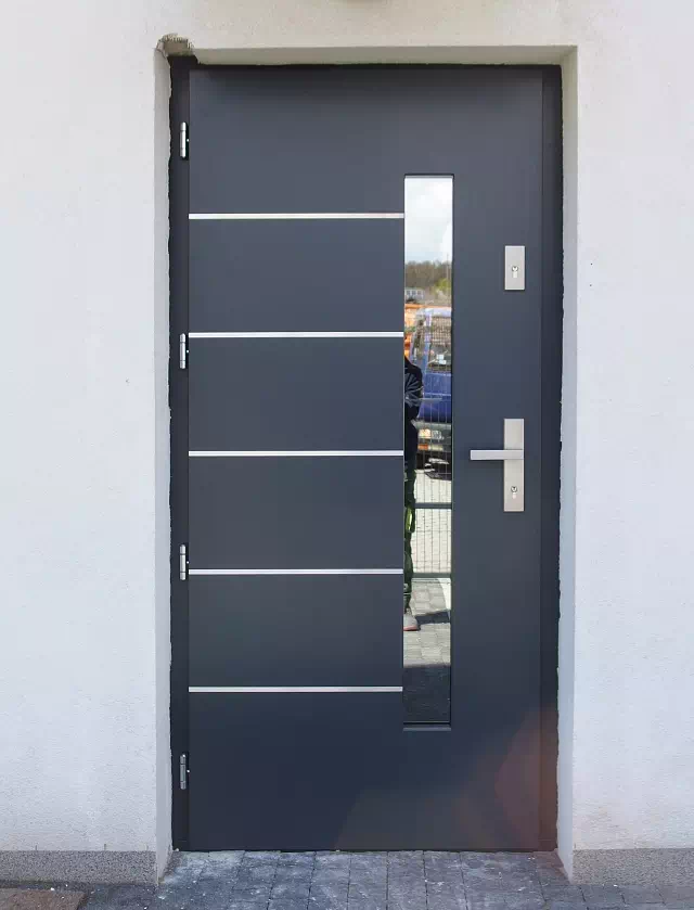 Widok elewacji domu z zamontowanymi drzwiami wzór 427,1 wymalowanymi w kolorze antracyt.