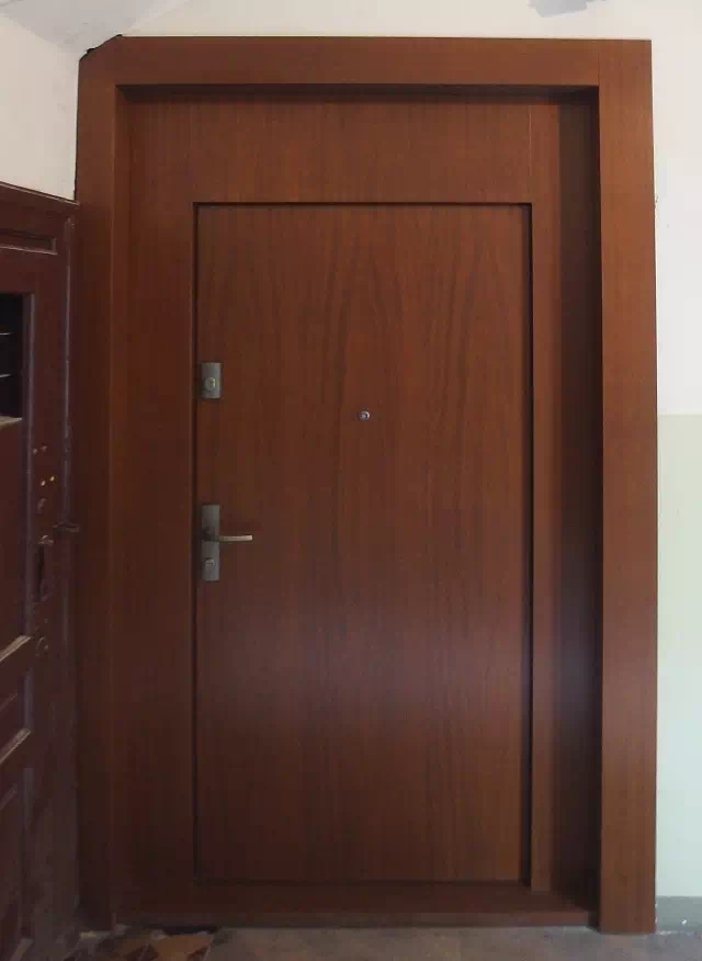 Widok elewacji domu z zamontowanymi drzwiami wzór 500C wymalowanymi w kolorze teakowe.