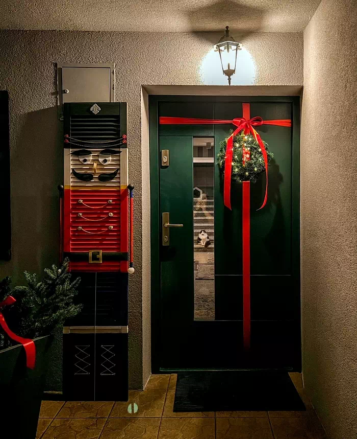 Widok elewacji domu z zamontowanymi drzwiami wzór 413,11 wymalowanymi w kolorze zielone.