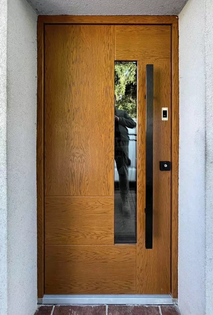 Widok elewacji domu z zamontowanymi drzwiami wzór 413,11c wymalowanymi w kolorze dębowe ciemny dąb.