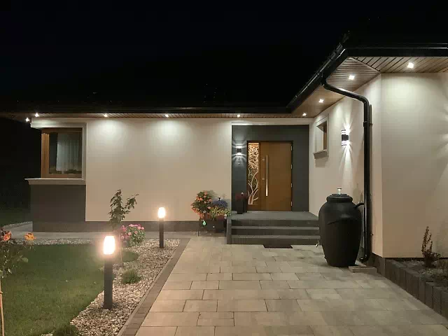 Widok elewacji domu z zamontowanymi drzwiami wzór 430,13b wymalowanymi w kolorze złoty dąb.