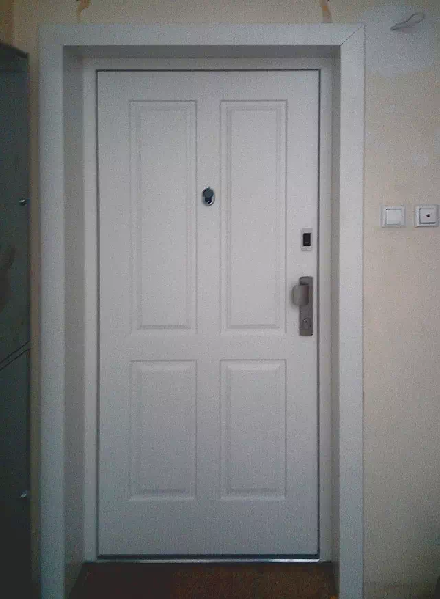 Widok elewacji domu z zamontowanymi drzwiami wzór 534,9 wymalowanymi w kolorze białe.