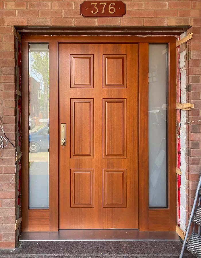 Widok elewacji domu z zamontowanymi drzwiami wzór 534,5 wymalowanymi w kolorze złoty dab.