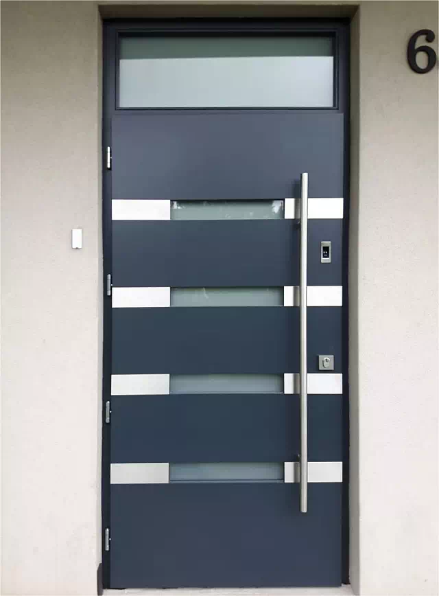 Widok elewacji domu z zamontowanymi drzwiami wzór 422,1 wymalowanymi w kolorze antracyt.